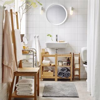 A white bathroom with wooden vanity unit and 2-in-1 chair and towel storage