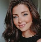 A woman smiles into the camera
