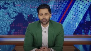 Hasan Minhaj in white shirt and green blazer guest hosting The Daily Show