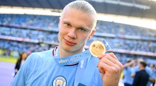 Erling Haaland of Manchester City holds his Premier League winners' medal after the Premier League match between Manchester City and Chelsea at the Etihad Stadium on May 21, 2023 in Manchester, England.