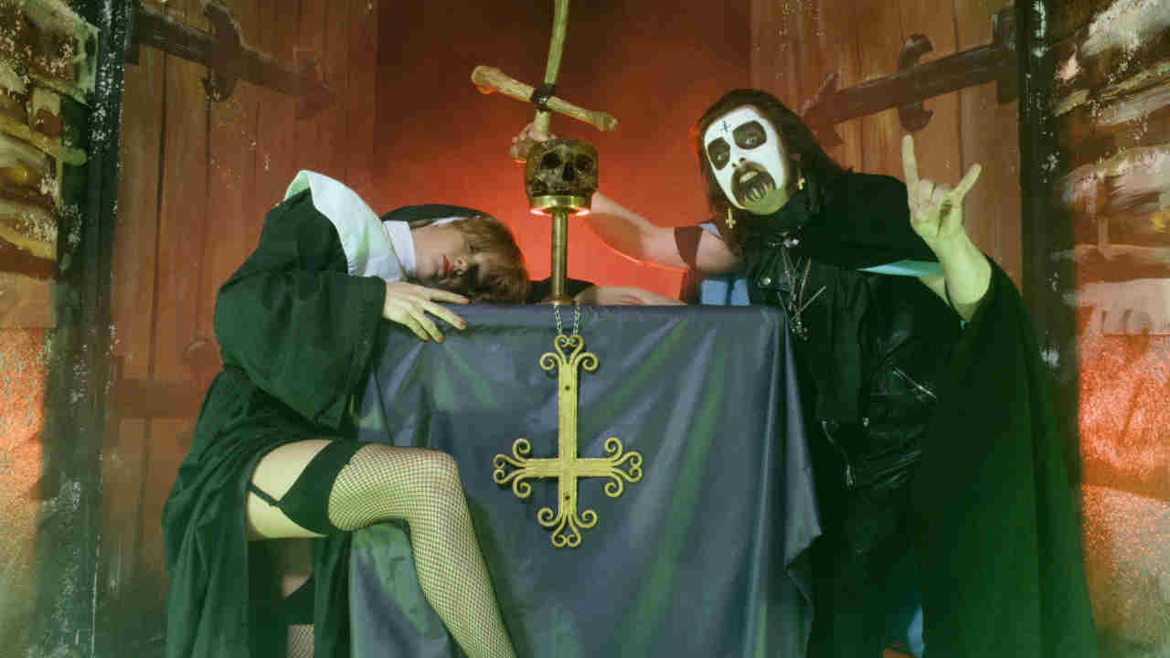 King Diamond posing for a photograph in make-up with a crucifix and a nun in 1983