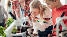 students using a microscope in a classroom