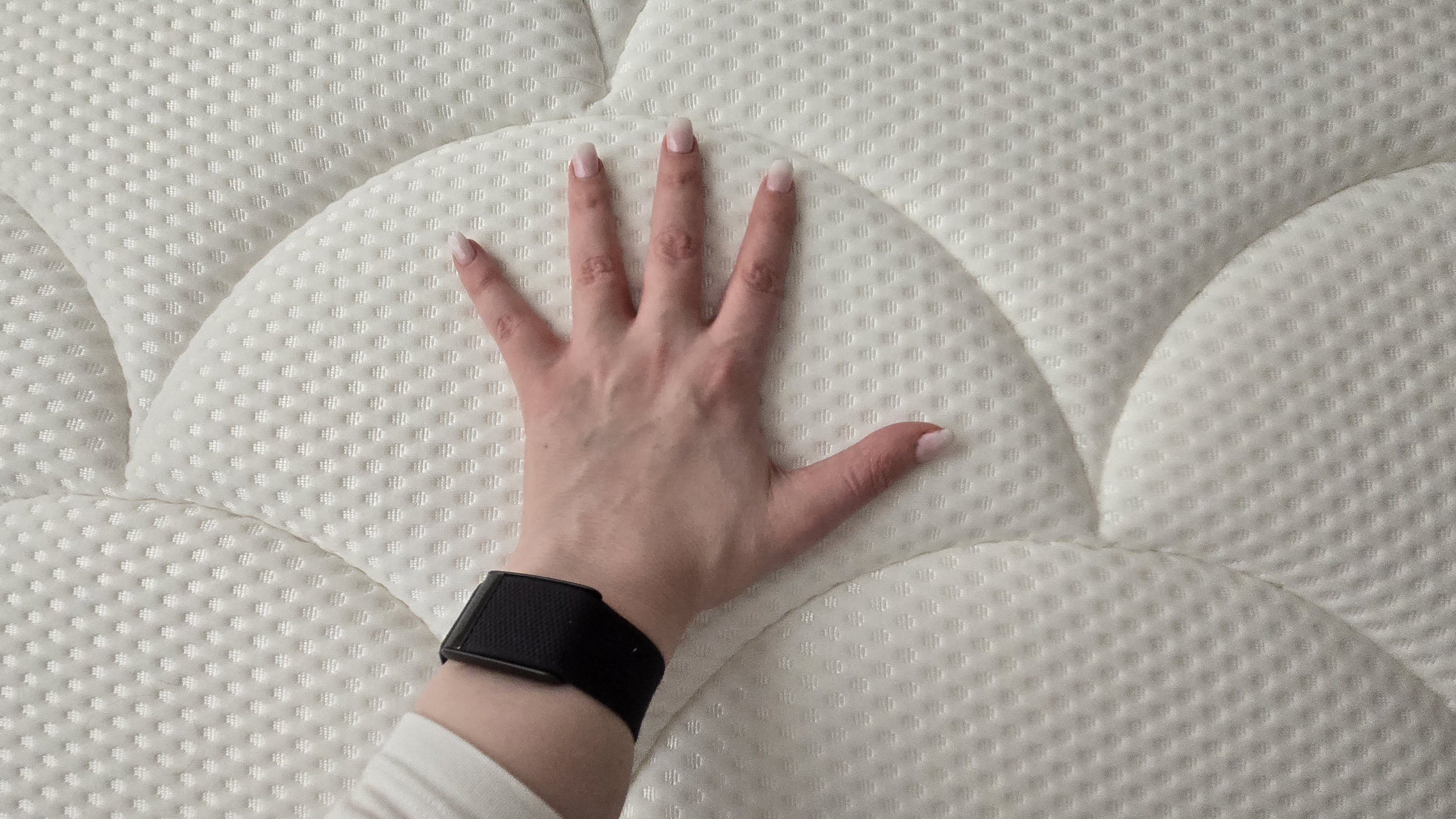 A Tom's Guide tester's hand placed on the surface of the DreamCloud Hybrid mattress to test how cooling it is