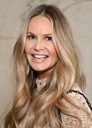 Supermodel Elle Macpherson in a cream and black lacy top