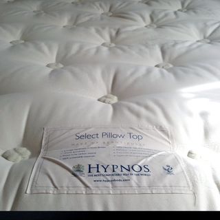 A close up of the Hypnos Select Pillow Top mattress labels and hand tufted surface