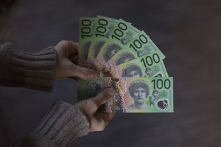 A woman holds Australian banknotes