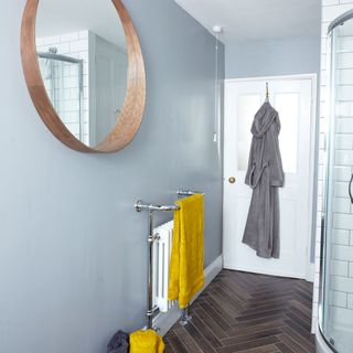bathroom with round mirror and white door