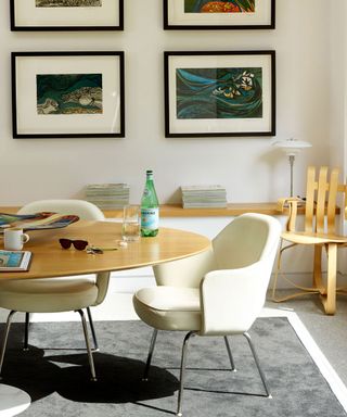 dining room with gallery wall and oval shaped cream colour table and chairs