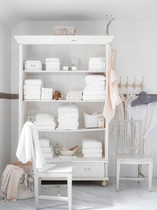 Towel cupboard filled with white towels