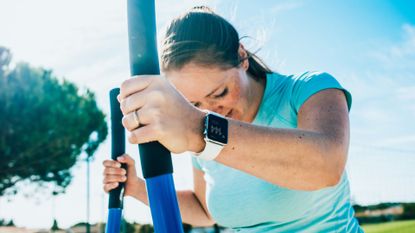 Woman using resistance machines in park in sunshine, representing the one-set rule for strength training