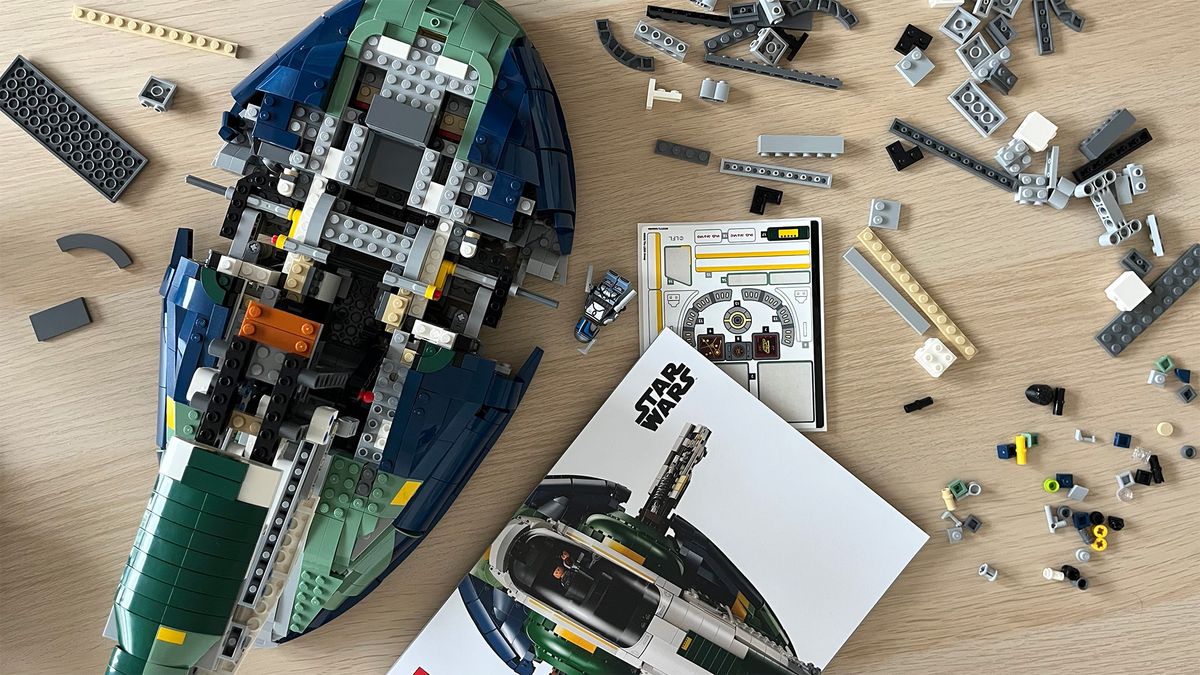 Lego Star Wars UCS Jango Fett&rsquo;s Firespray-Class Starship (75409) mid-build on wooden tabletop next to lots of Lego pieces and an instruction booklet