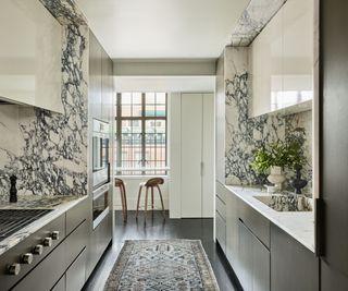 kitchen with marble backsplash and walls and white cabinets