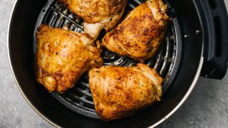 Close up of chicken thighs cooking in an air fryer