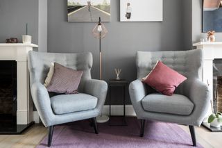 Living room makeover: close up of two grey armchairs with plum and purple cushions
