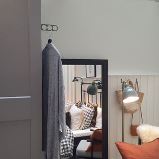 A bedroom with a grey cardigan hanging on an IKEA KOMPLEMENT Valet Hanger on the outside of a wardrobe