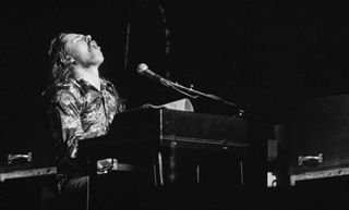 Bob Seger sitting at the piano onstage