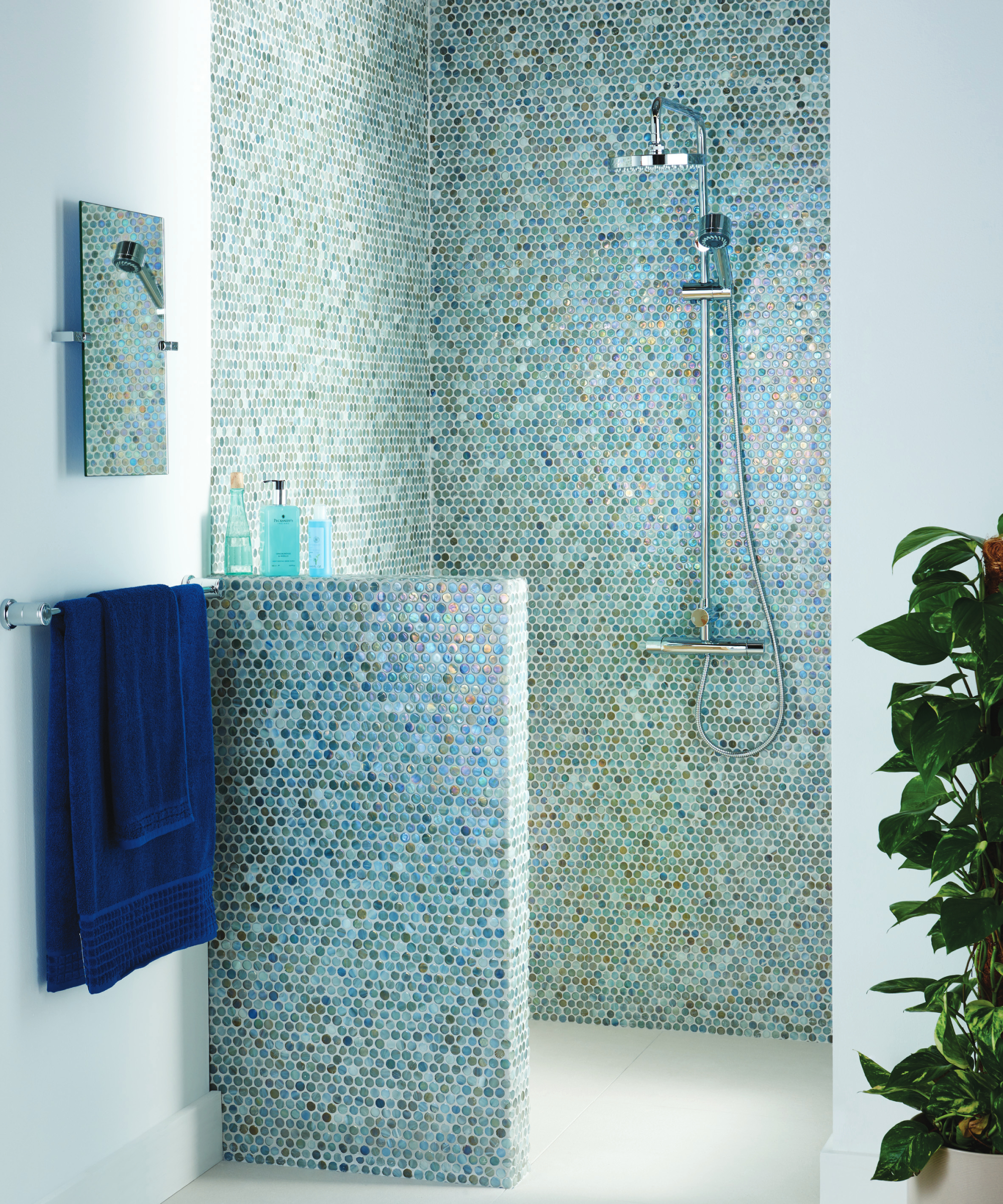 small shower area with half height wall with blue mosaic tiling