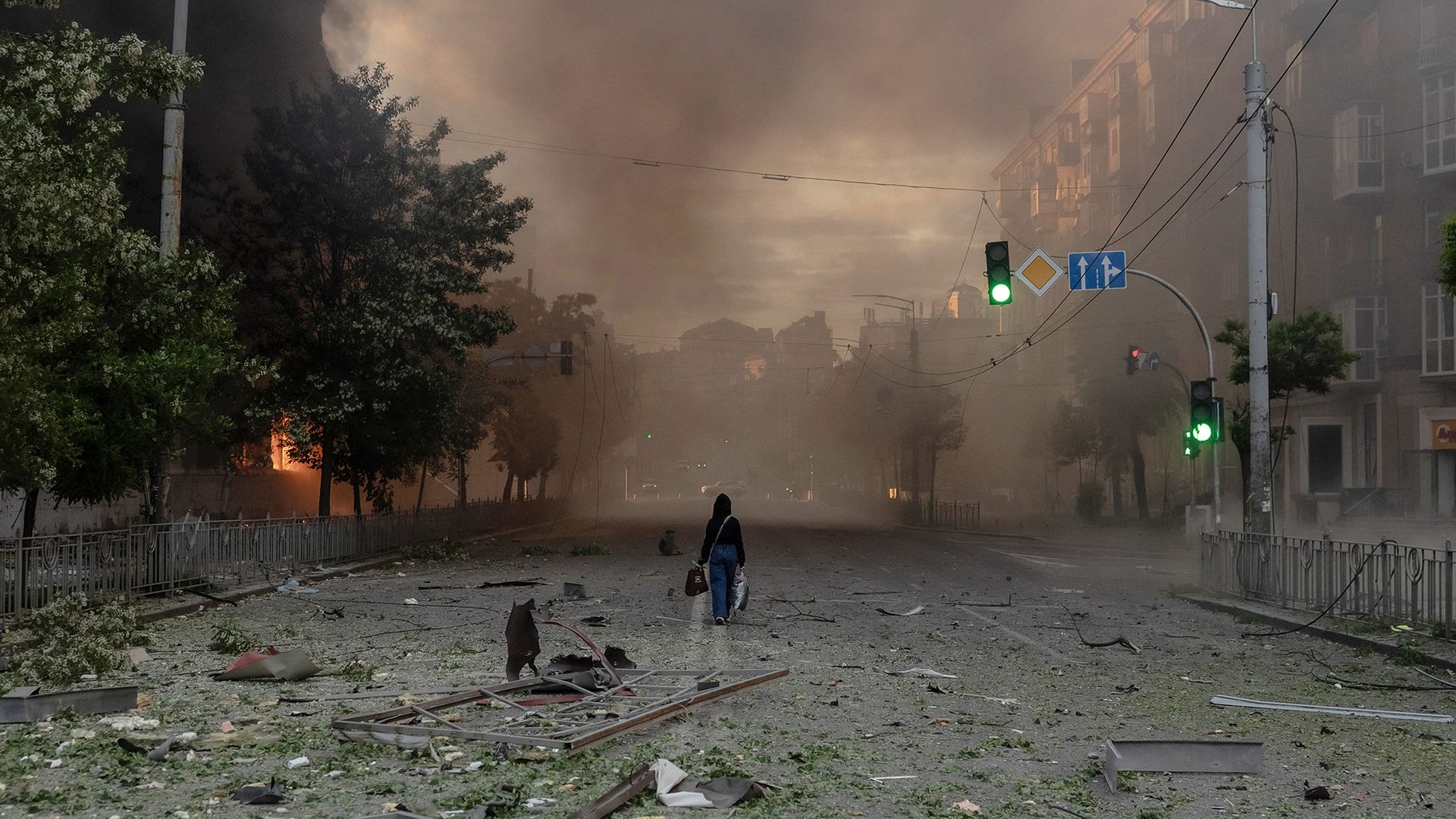 
                                A woman walks through a smoke-filled neighbourhood scattered with debris following intense Russian bombardment, in Kyiv, Ukraine
                            