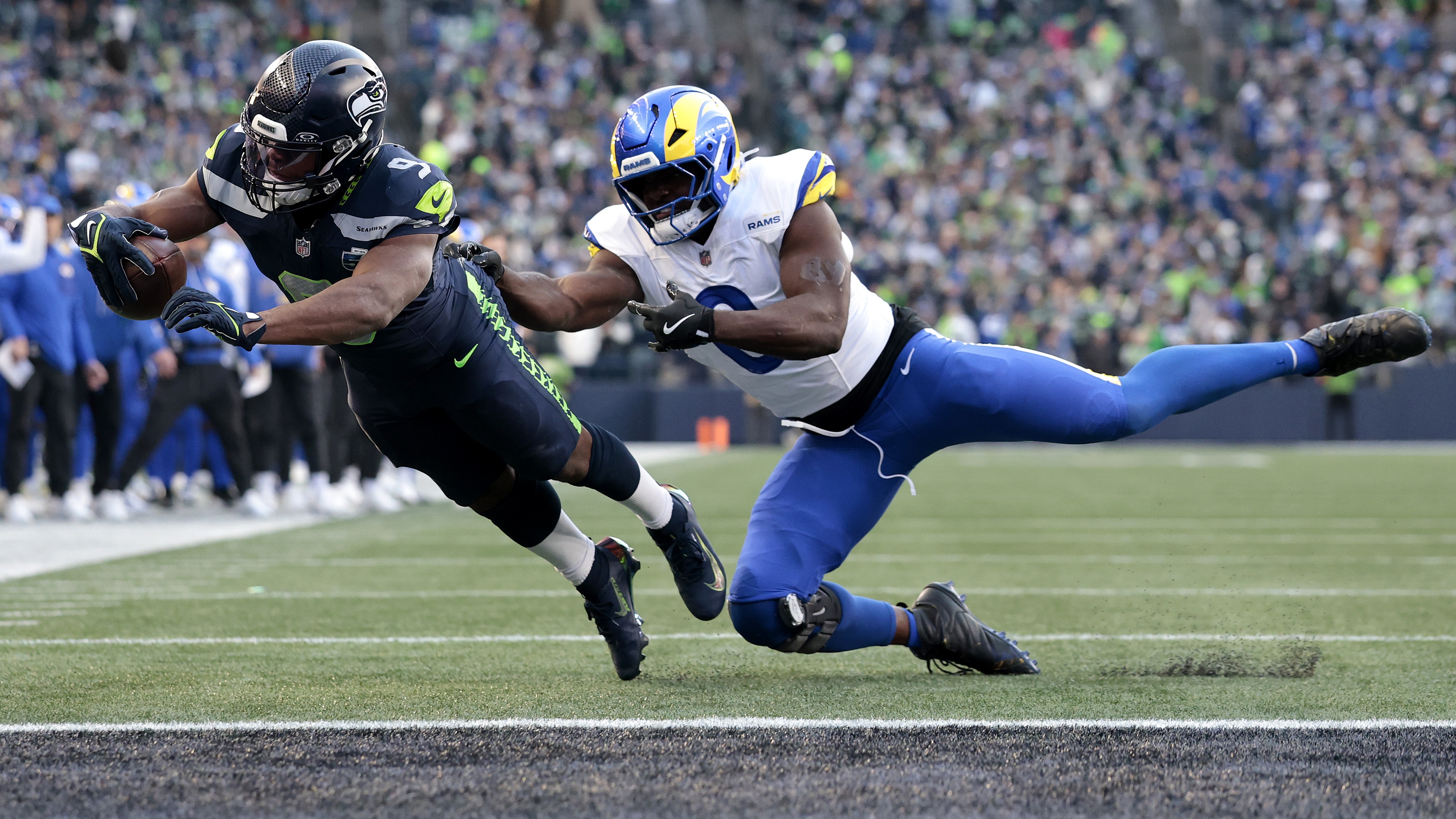Kenneth Walker III #9 of the Seattle Seahawks scores a first quarter touchdown in front of Byron Young #0 of the Los Angeles Rams in the NFC Championship game at Lumen Field on January 25, 2026 in Seattle, Washington.