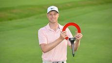 Cam Davis holds up the Rocket Mortgage Classic trophy after his win in 2024