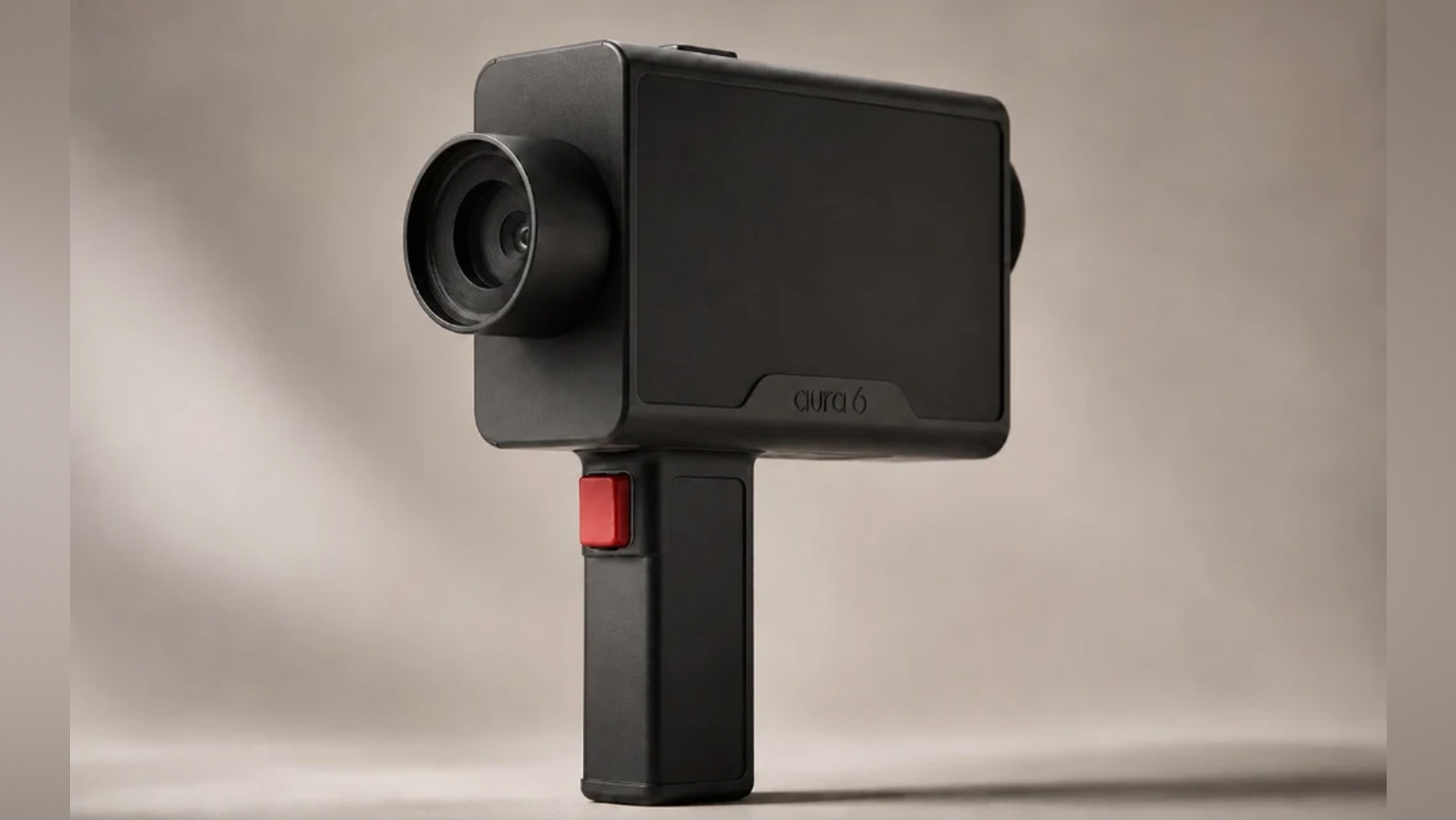 Aura6 camera with a white background. It is box shaped and black with a pistol-grip handle.