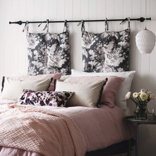 Bed, pink bedding, hanging floral cushion headboard in a teenage girls bedroom