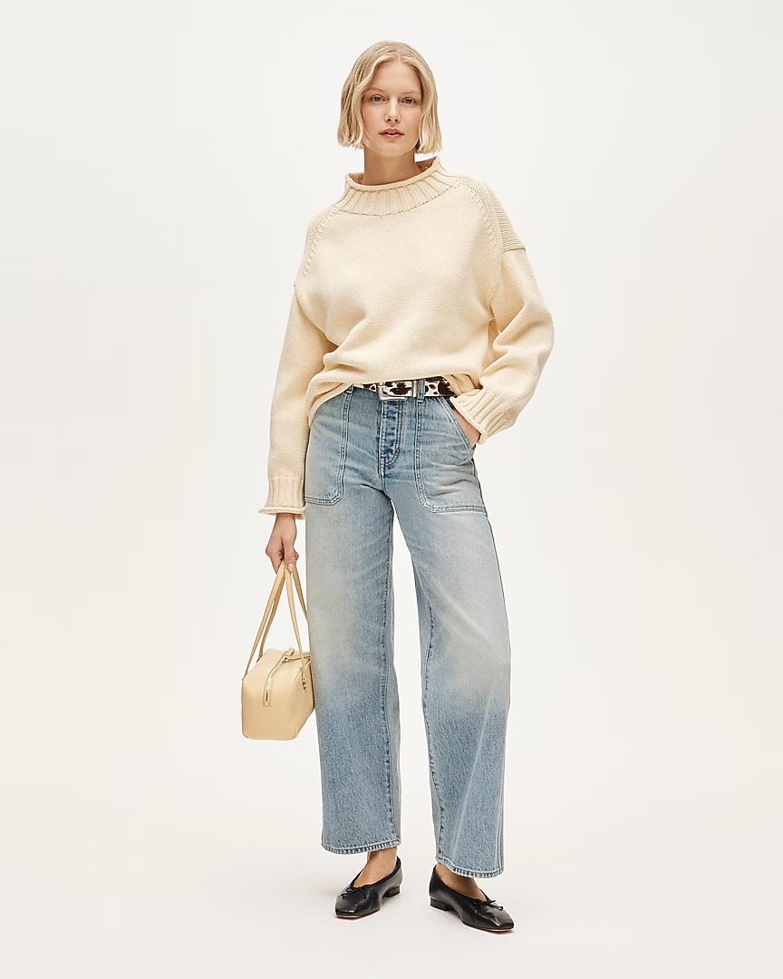 J.Crew outfit with a butter-yellow rollneck sweater, cow-print belt, yellow shoulder bag, barrel jeans, and black ballet flats