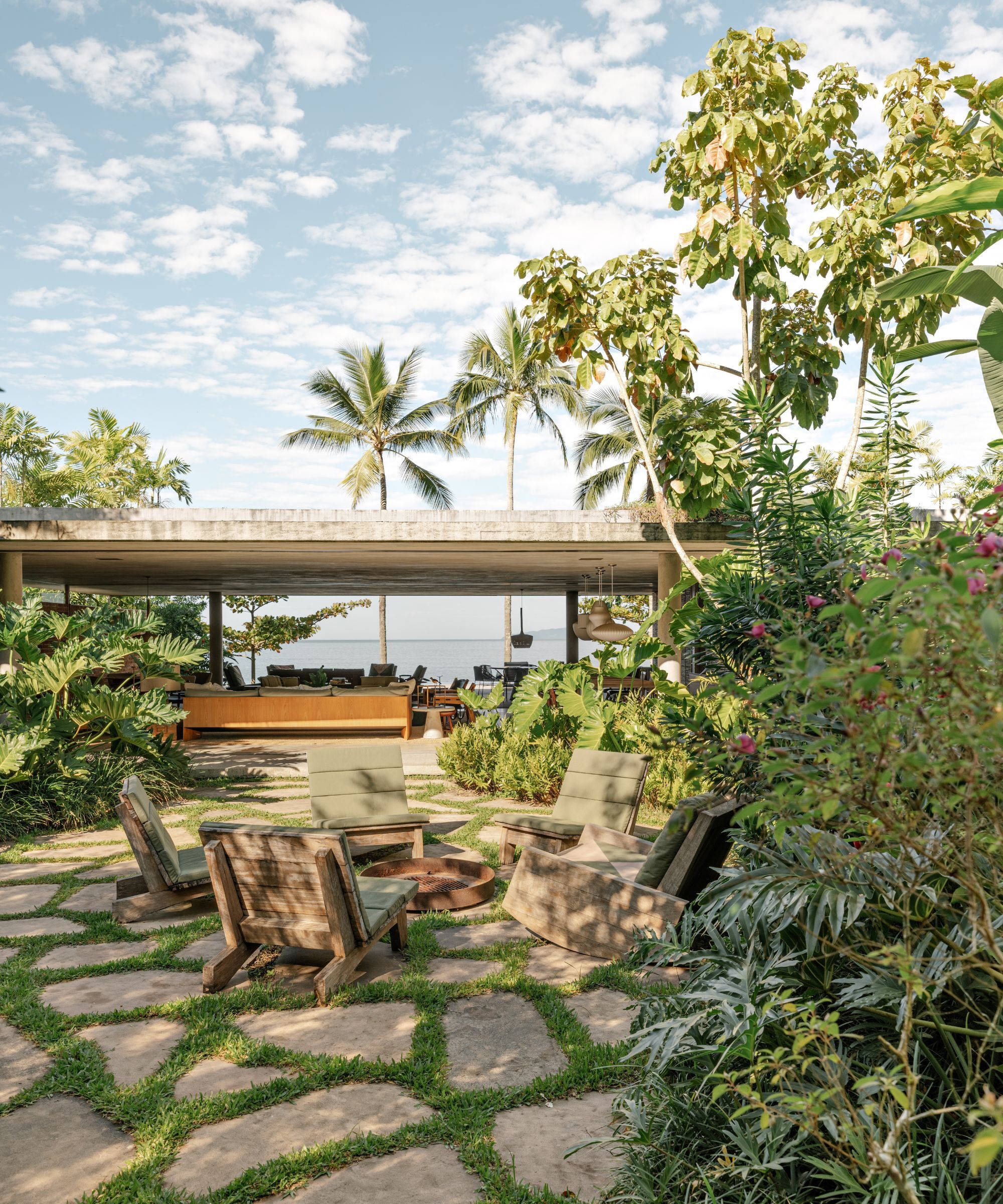 The garden to a beach house leading to an open plan kitchen with the beach beyond