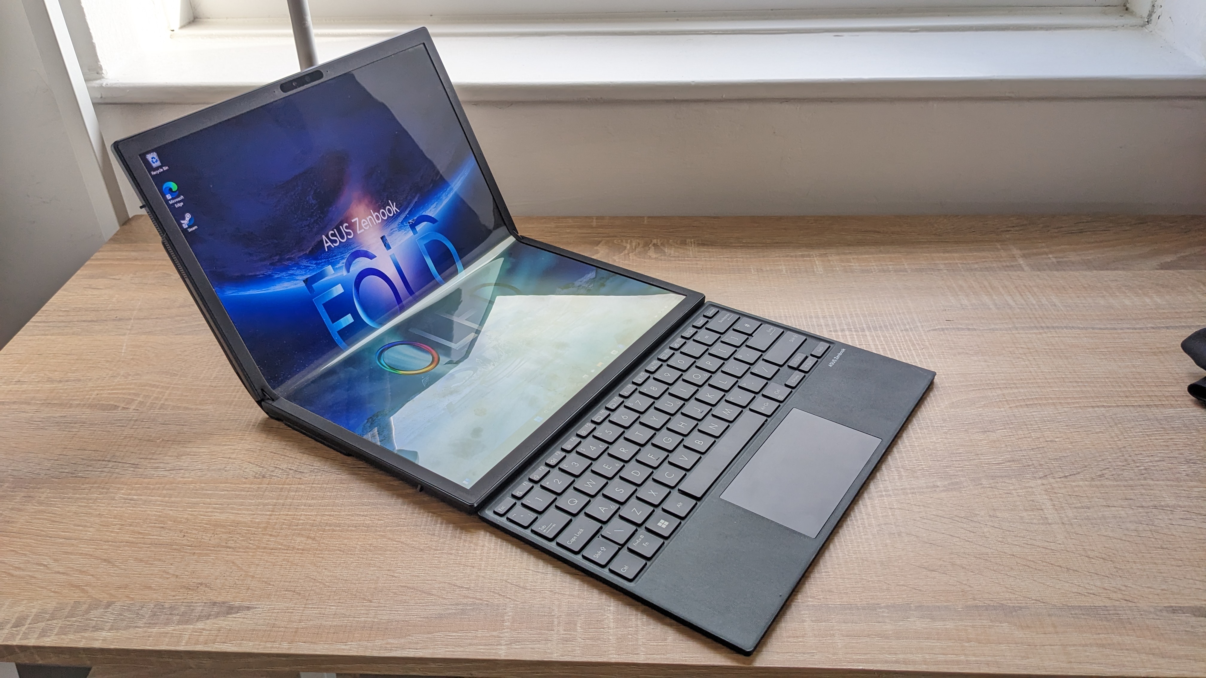 The Asus Zenbook 17 Fold OLED pictured on a wooden desk.