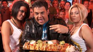 Adam Richman standing next to two women in front of the Big Badass Burrito