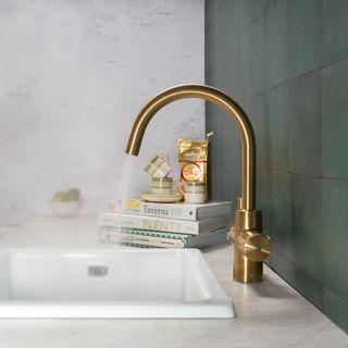 polished brass boiling water tap above white sink