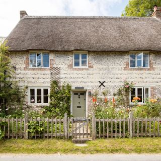 thatched cottage with stone walls and cottage garden