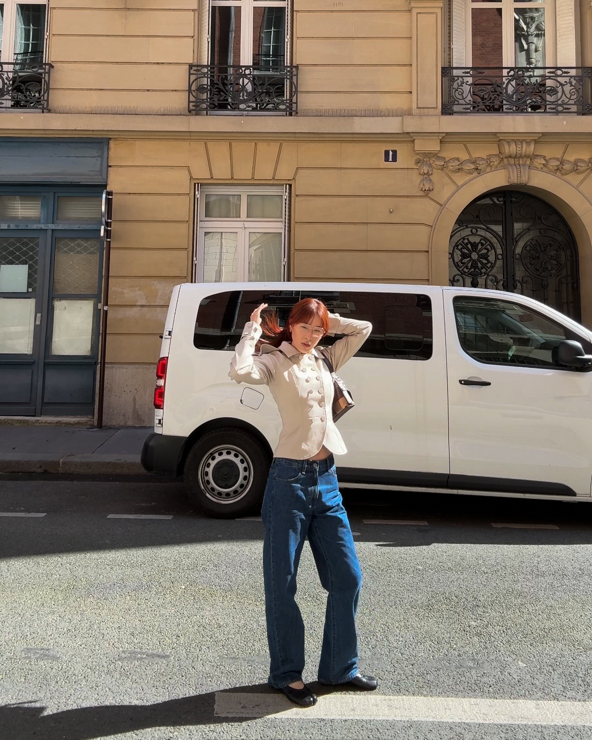 @kristinamichelleang wearing a tan blazer, dark-wash jeans, and ballet flats in Paris.