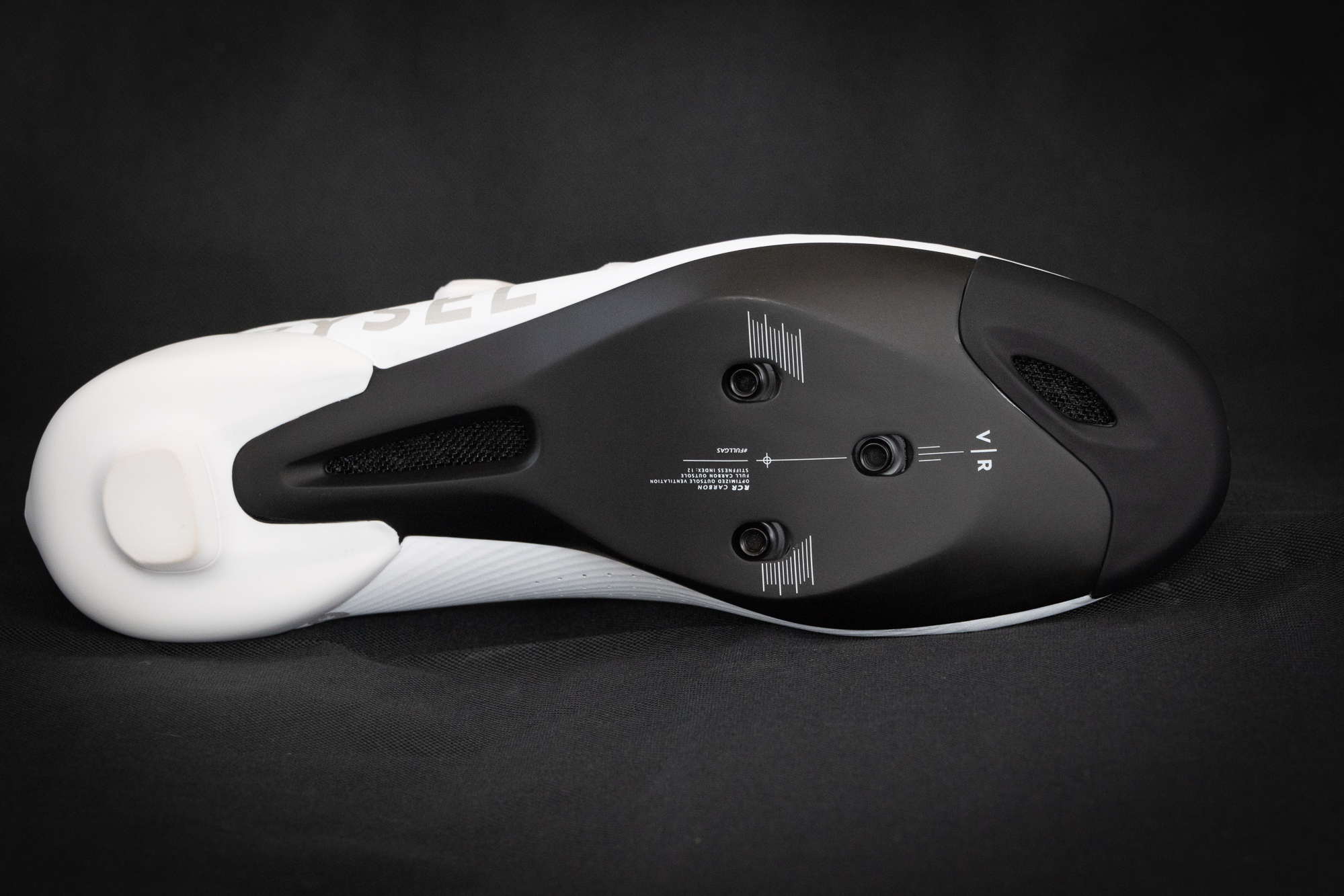 close up of the carbon sole of a white road shoe showing the ventilation holes