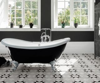 black and white geometric floor tiles with black freestanding bath and black screen divider