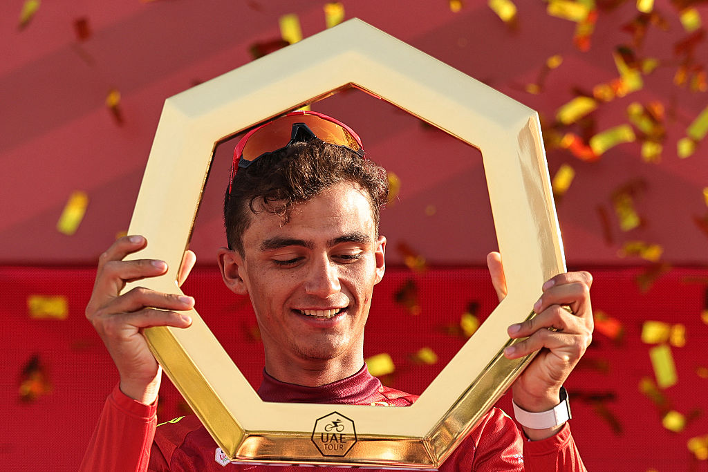 Championship first place winner UAE Team Emirates's Mexican rider Isaac Del Toro Romero celebrates with the trophy on the podium after the seventh and final stage of the UAE Tour cycling event from Zayed National Museum to Abu Dhabi Breakwater in Abu Dhabi on February 22, 2026. (Photo by Fadel SENNA / AFP)