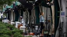 A member of the media outside the White House after three media outlets announced they will sue to maintain their ability to enter the White House grounds and other networks stopped filming.