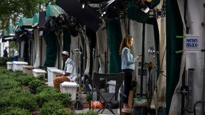 A member of the media outside the White House after three media outlets announced they will sue to maintain their ability to enter the White House grounds and other networks stopped filming.