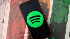 Spotify logo on an Apple iPhone 17 Pro Max sitting on vinyl records
