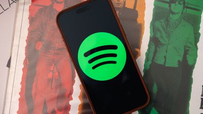 Spotify logo on an Apple iPhone 17 Pro Max sitting on vinyl records