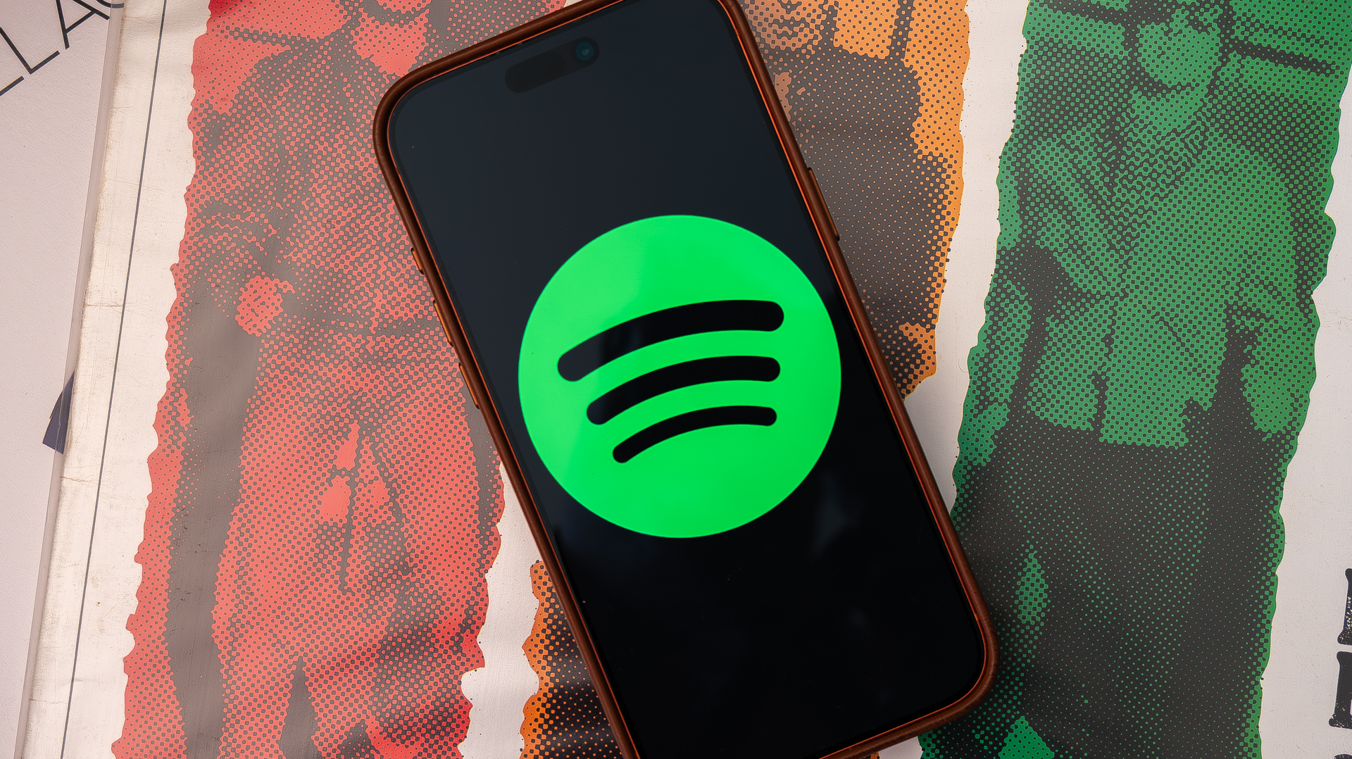 Spotify logo on an Apple iPhone 17 Pro Max sitting on vinyl records