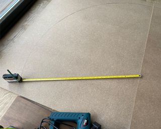 Tape measure extended over mdf sheet on the floor