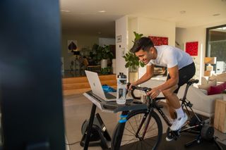 Image shows a rider training indoors instead of cycling in the rain.