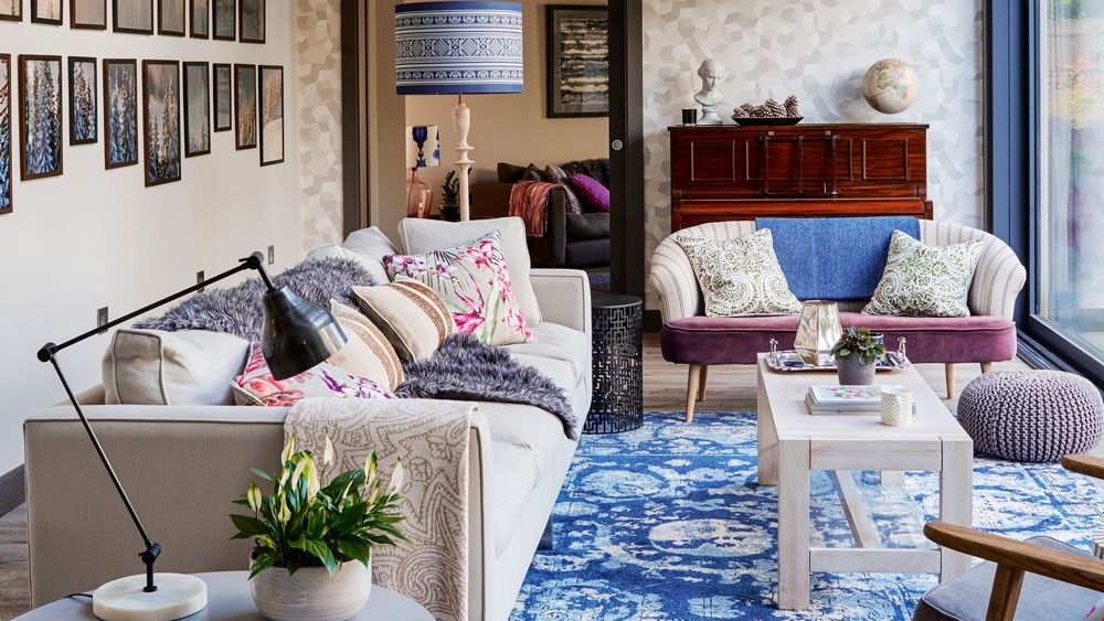 a living room with printed wall and blue carpet flooring