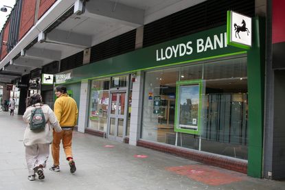  A couple walking past a branch of Lloyds Bank in London
