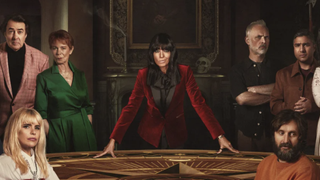 Host Claudia in red velvet jacket at the Round Table in The Celebrity Traitors UK season 2 TV show on BBC 