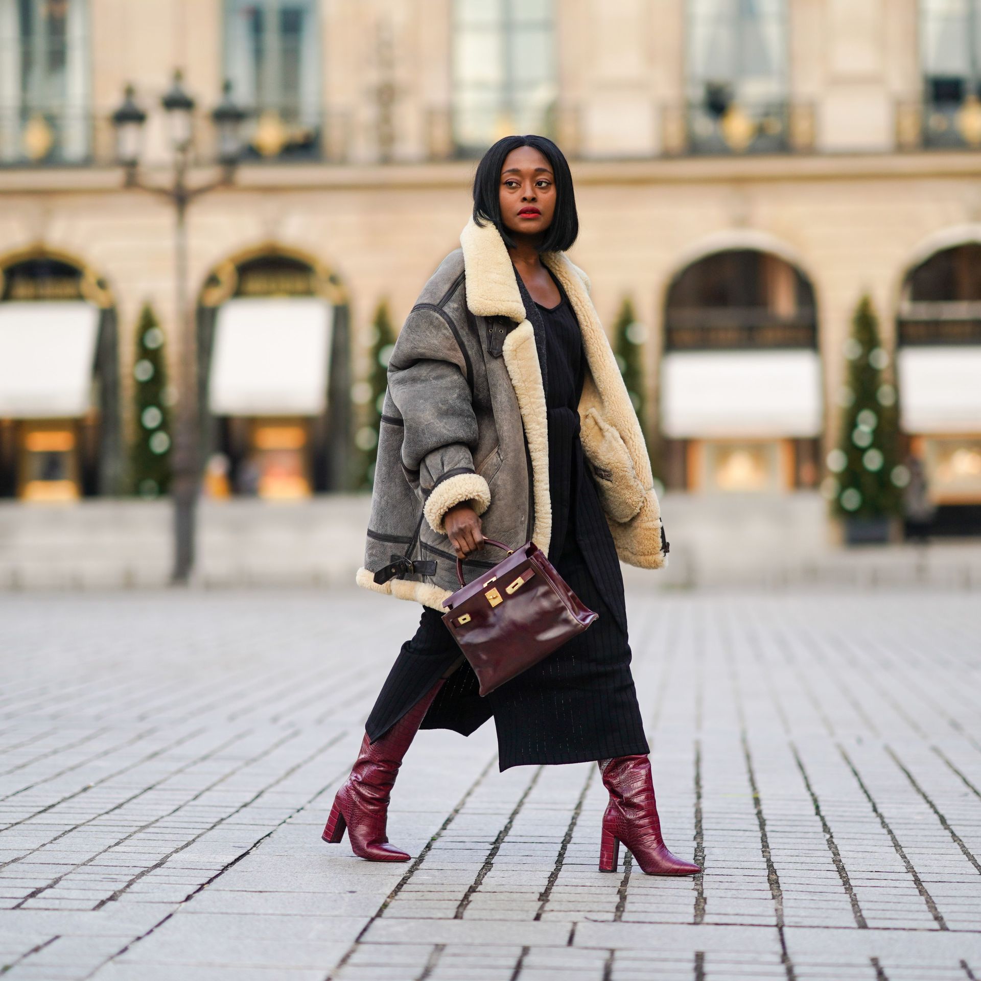 paris, france december 06 fashion blogger linaose wears a bombardier aviator browngray jacket with sheep wool inner lining from acne studio, a black slit dress from sancia, a burgundy leather bag kelly hermes 28, purple leather crocodile pattern high heeled pointy boots from bianca di, on december 06, 2020 in paris, france photo by edward berthelotgetty images