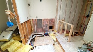 The inside of a renovastion with the floorboards lifted ready for insulation to be laid