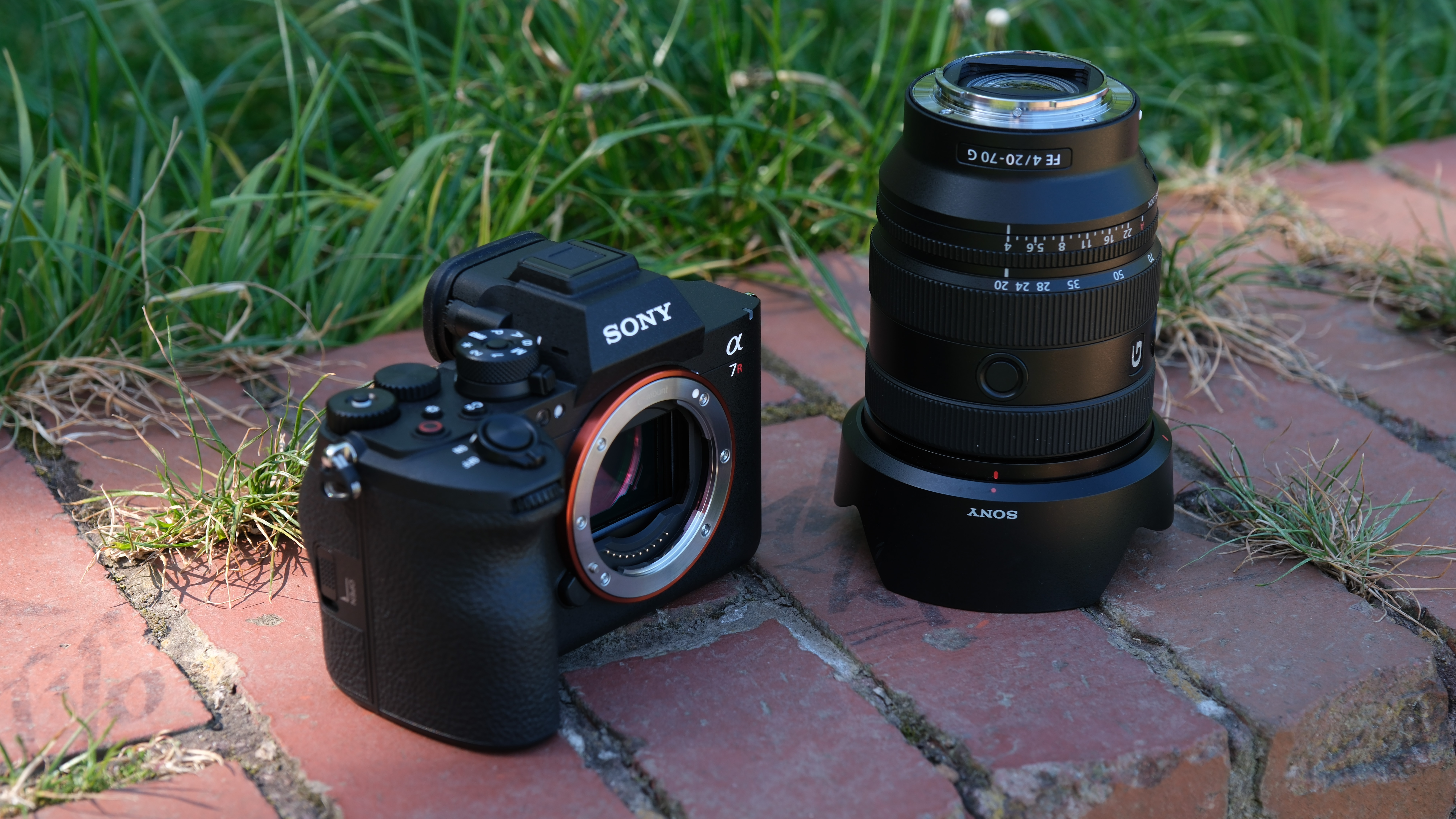 Sony A7R VI body and Sony FE 20-70mm G lens on brick paving.