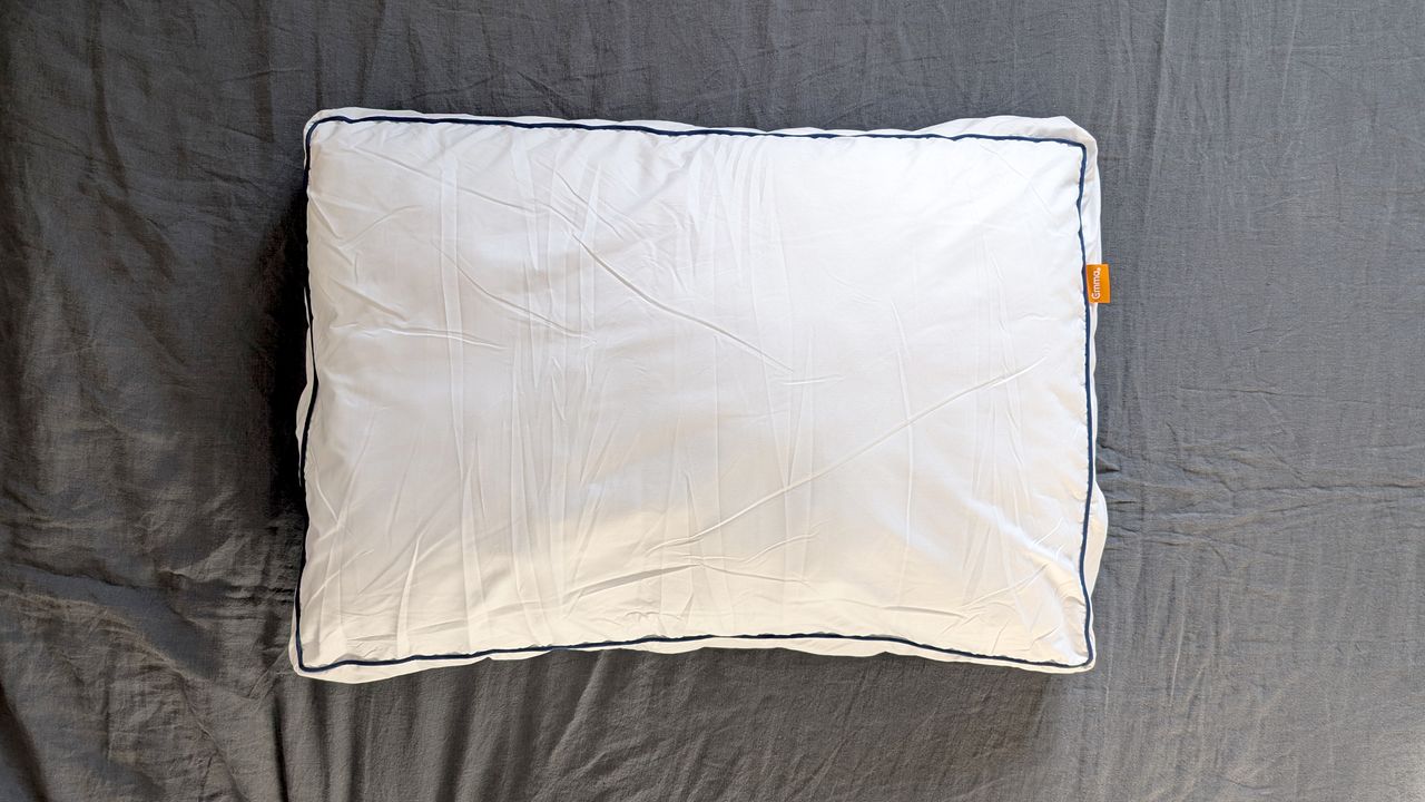 The Emma Original Hybrid Pillow being tested on a bed with a grey linen duvet cover